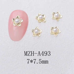 Detail of 7x7.5mm golden flower nail art charm with pearl center on pink nails