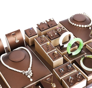 Macro view of luxury dark brown leather jewelry display set with champagne gold metal frames