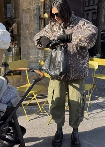 Detail der Leopard-Print Pufferjacke mit Kapuze, Cargo-Hose in Olivgrün und Stiefeln