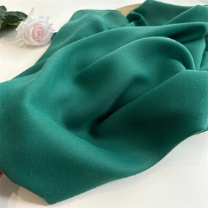 Detail of emerald green linen scarf showing soft texture and fine fabric grain