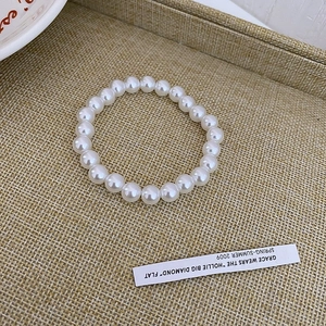 Detailed view of white circular synthetic pearls on an elegant woven display tray