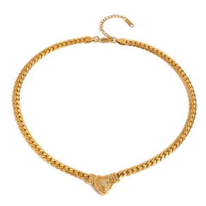 Macro shot of gold Cuban chain heart pendant necklace with shimmering zircon stones