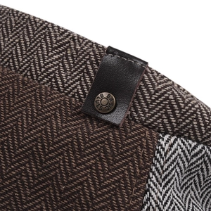 Close-up of herringbone fabric texture with leather trim and antique bronze rivets