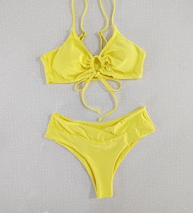 Flat lay of bright yellow halter neck bikini with ring detail and V-shaped waist bottom