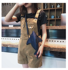 Detailed view of creative shark-shaped crossbody bag paired with corduroy overalls