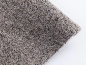 Close-up of premium brown knit fabric with soft texture on bomber jacket and skirt set