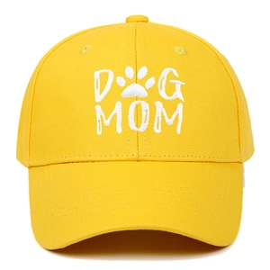 Close-up of white Dog Mom embroidery and paw print on yellow cotton baseball cap fabric