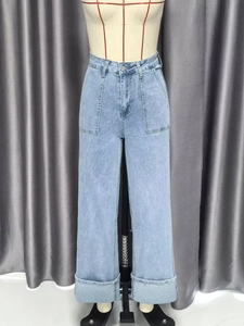 Detail van een lichtblauwe jeans met hoge taille, wijde pijpen, cargozakken en omslagzoom