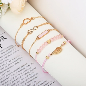 Detail of 5-piece gold bracelet set with pink enamel heart and infinity charms