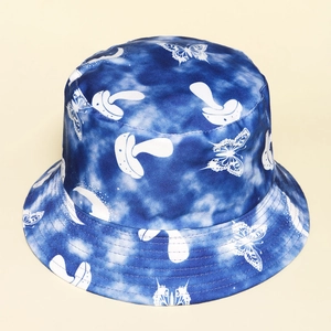 Detail of blue tie-dye bucket hat featuring butterfly and mushroom prints in sturdy canvas