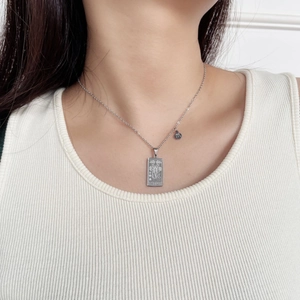 Close-up of Scorpio zodiac necklace in silver stainless steel on a female model
