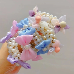 Detail of colorful bow hair ties with faux pearl beads for girls hair styling