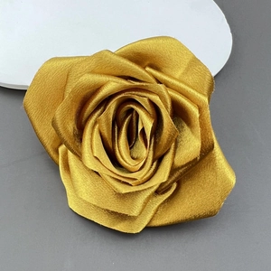 Macro detail of the golden satin rose fabric layers and shiny petal textures