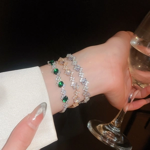 Three elegant zircon bangles in gold and silver finish worn in a social setting