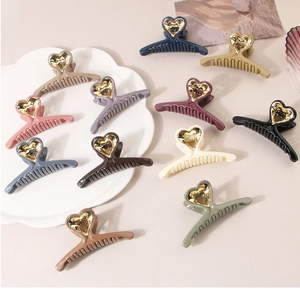 Detail of colorful matte shark hair clips featuring metallic gold heart decorations