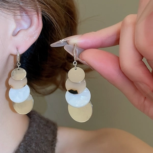 Detail view of geometric acrylic tassel drop earrings with colorful stacked circular resin discs