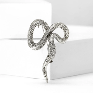 Detailed close-up of a silver snake brooch with intricate scale texture on a white background