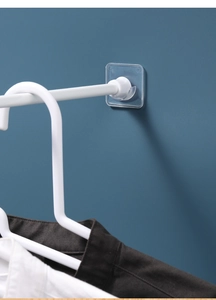 Support de tringle adhésif sur mur bleu montrant la base transparente et le support blanc