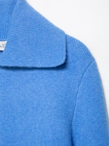 Close-up of soft blue knit fabric texture and collar detail on a women sweater