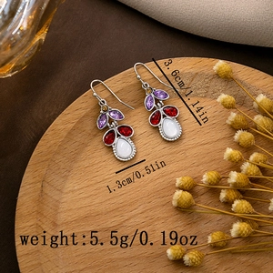Detail view of colorful gemstone earrings with dimensions 3.6cm by 1.3cm on a tray
