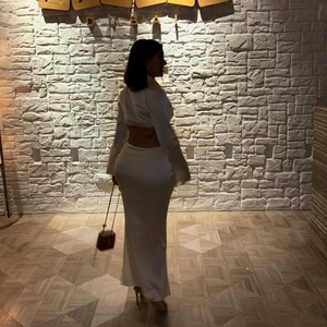 Vue arrière d'une élégante robe longue en satin blanc dos nu avec une coupe ajustée