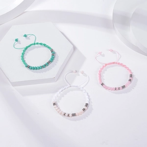 Detailed view of Morse code bracelets in pink green and white with adjustable woven cords