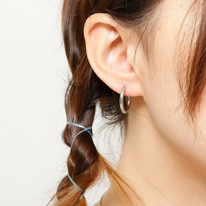 Close-up of classic silver stainless steel hoop earrings on model with polished finish