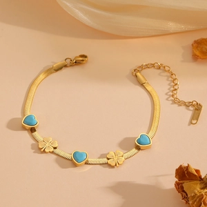 Bracelet chaîne serpent en acier doré avec breloques cœurs bleus et trèfles
