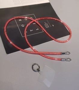 Close-up of red glitter crossbody phone lanyard with silver lobster clasps and clear pad