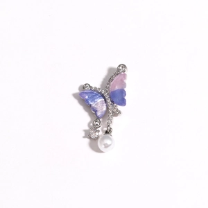 Macro detail of asymmetric butterfly pendant with purple gradient wings and white pearl drop