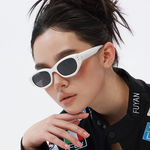 Detail of white cat eye sunglasses with grey lenses and dual rivet accents on the temples