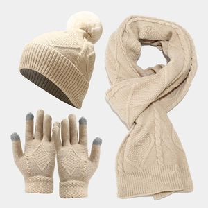Close-up of beige knit set featuring a beanie with pompom, scarf and touchscreen gloves