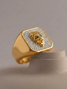 Macro side view of 18k gold plated lion head signet ring with green eyes and white crystals