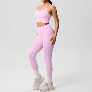 Detail of pink yoga set showing high-waist leggings and cross-back sports bra on model