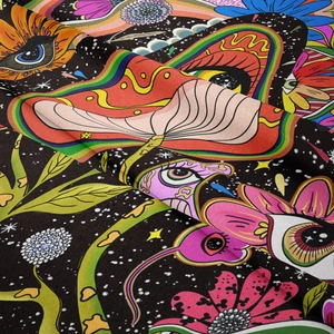Vue détaillée des motifs de champignons et yeux psychédéliques sur tissu noir