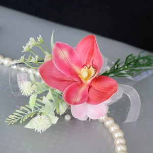 Pink orchid corsage with white mesh ribbon and green leaves for wedding glass decor