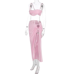 Détail d'un ensemble de plage rose avec haut court torsadé et jupe longue fendue