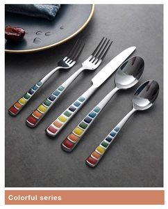 Close-up of colorful handle stainless steel cutlery set with blue plate and dessert