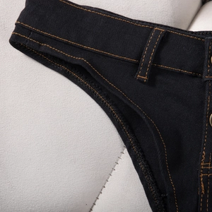 Vue détaillée du short en denim noir avec double surpiqûre orange et texture du tissu
