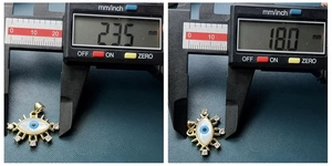 Detailed measurement of gold evil eye pendant with shell inlay showing 23.5mm by 18mm