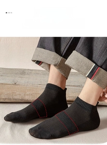 Close-up of black cotton ankle socks featuring a compression arch support band for men
