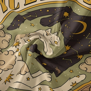 Close-up of bohemian wall tapestry featuring a black and white celestial cat pattern