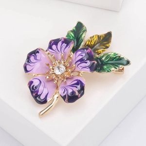 Detail of purple enamel peach blossom brooch with rhinestone center and gold finish