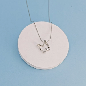 Minimalist silver butterfly pendant necklace with smooth snake chain on white stone display