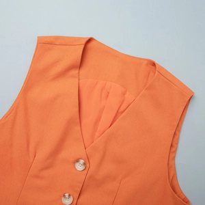 Detail of orange linen-textured vest featuring a V-neck and marble-patterned buttons