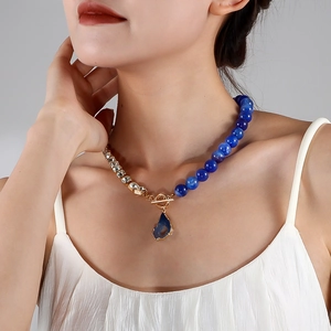 Detailansicht der asymmetrischen Halskette mit blauen Perlen und goldener Strasskette
