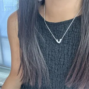 Close-up of a minimalist 925 sterling silver V-shaped necklace worn on a woman's neck