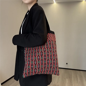 Detail of colorful geometric diamond pattern on a large soft knit tote shoulder bag