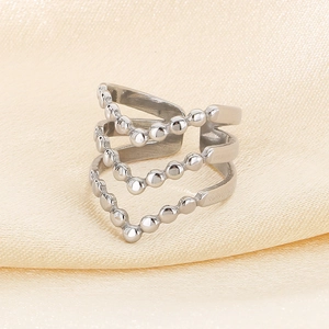 Close-up of silver layered V-shape ring with bead accents on yellow silk fabric