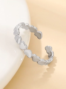 Dettaglio macro dell'anello aperto regolabile a forma di cuore argento su ceramica